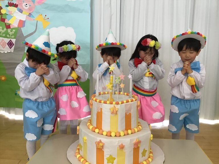 ケーキの後ろに並んで願い事をする園児たち