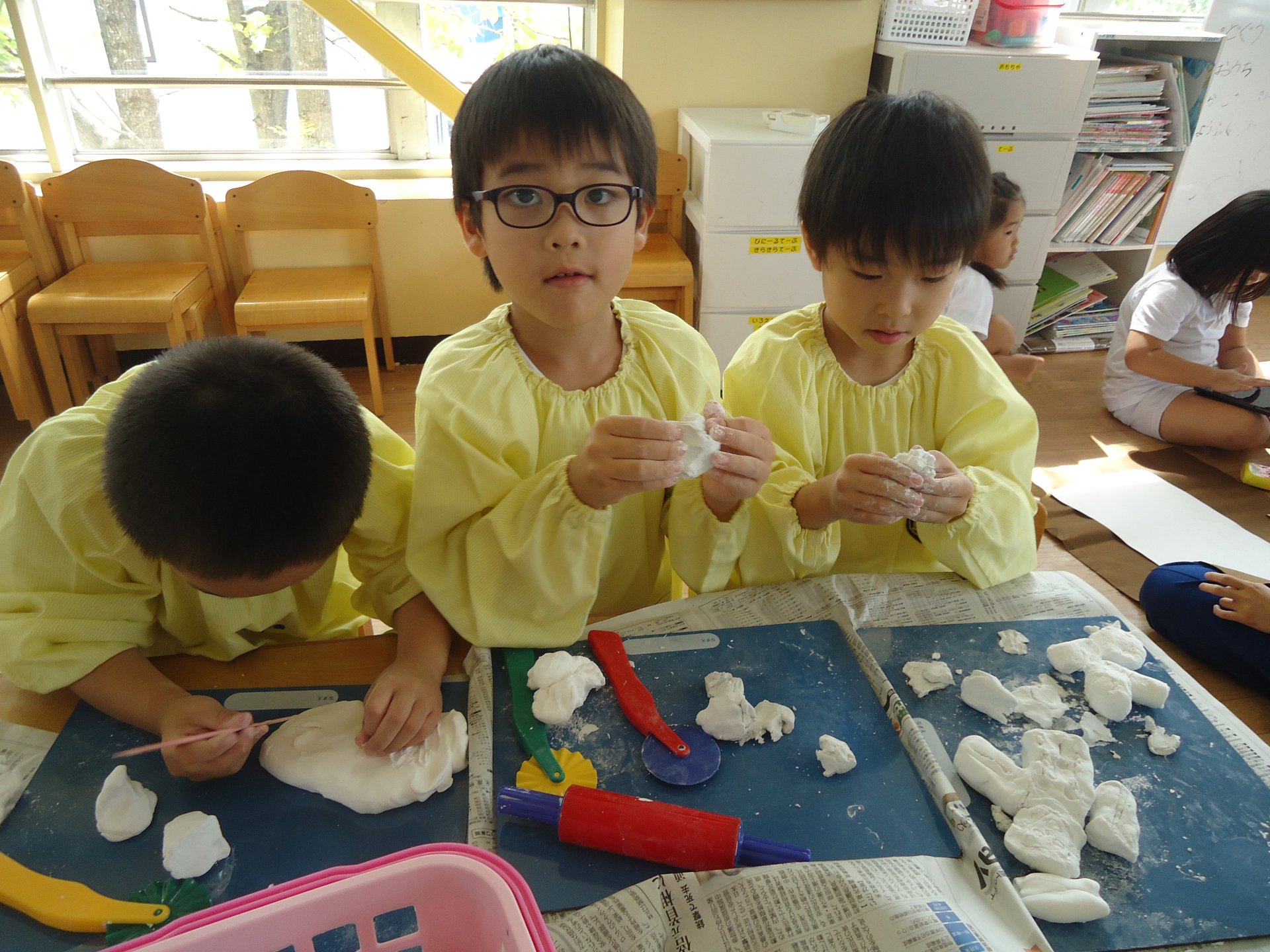 紙粘土で土偶おを作る園児たち