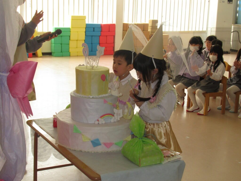 ケーキに飾り付けをする誕生児たち