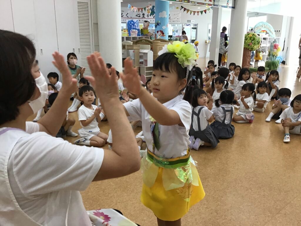 園長先生とハイタッチする誕生児