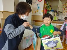 園長先生からプレゼントを受け取る誕生児