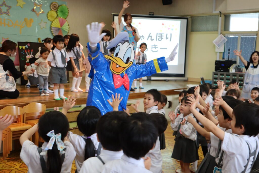 笑顔でドナルドダックとお別れする園児たち