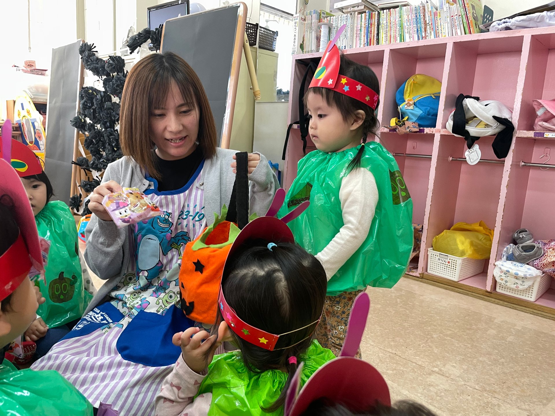 先生からお菓子を受け取る子どもたち