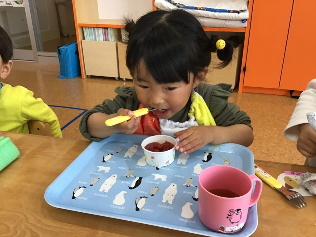 給食の時間にプーさんからもらったゼリーを食べる園児たち