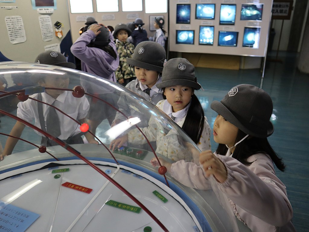 館内の星座に光るボタンを押す園児たち