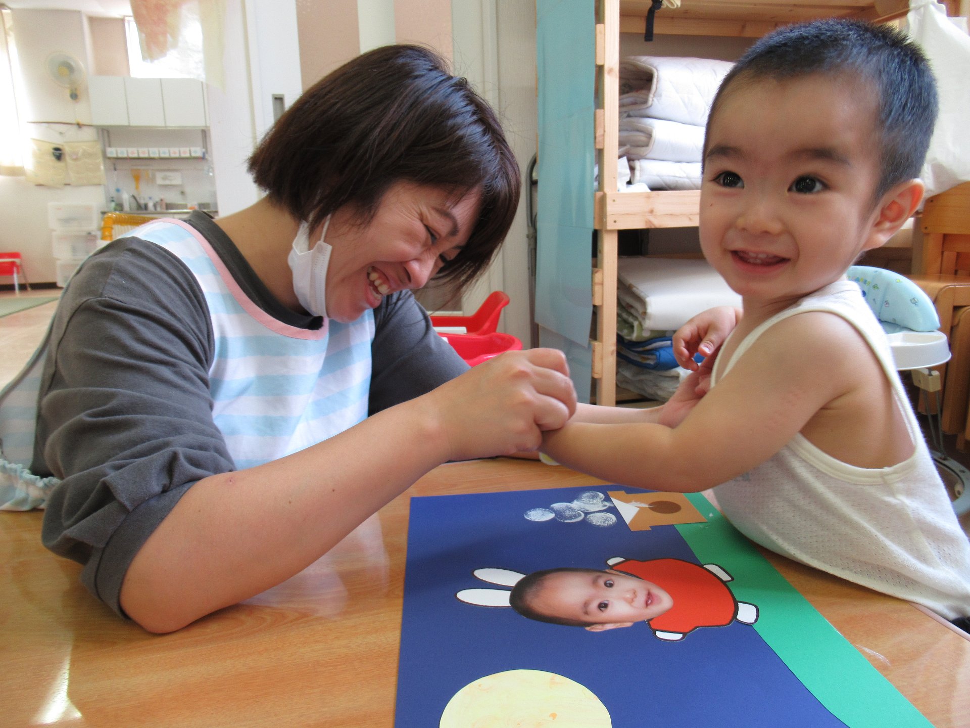 お父さんとお母さんとつづり制作のお団子をスタンプを押す園児