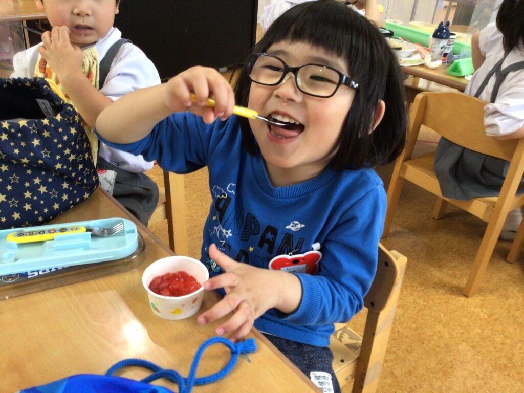 給食の時間にプーさんからもらったゼリーを食べる園児たち