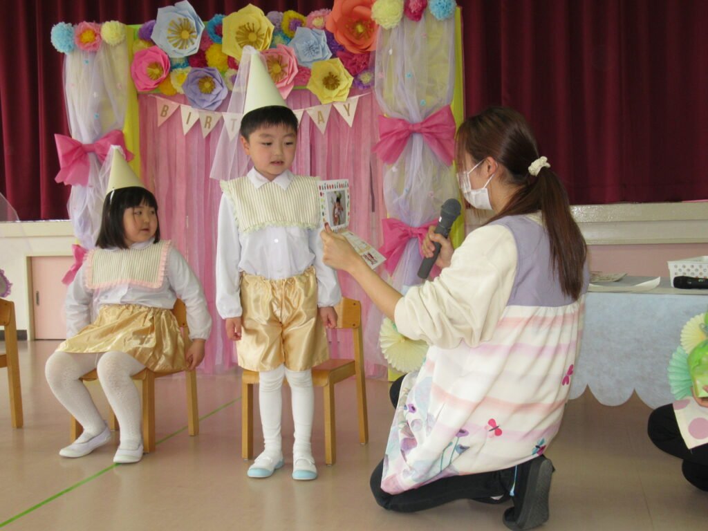 先生とお友だちからプレゼントを受け取る園児たち