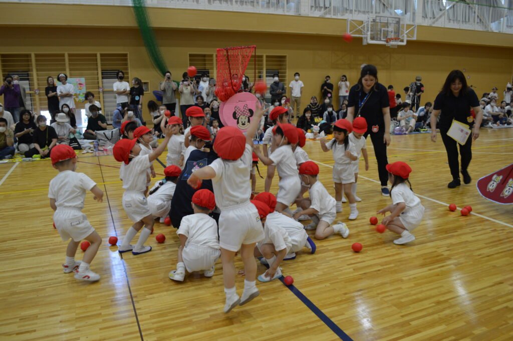 協力して玉入れする園児たち