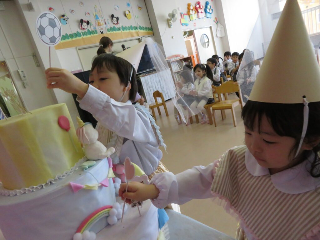 ケーキに飾り付けをする誕生児たち