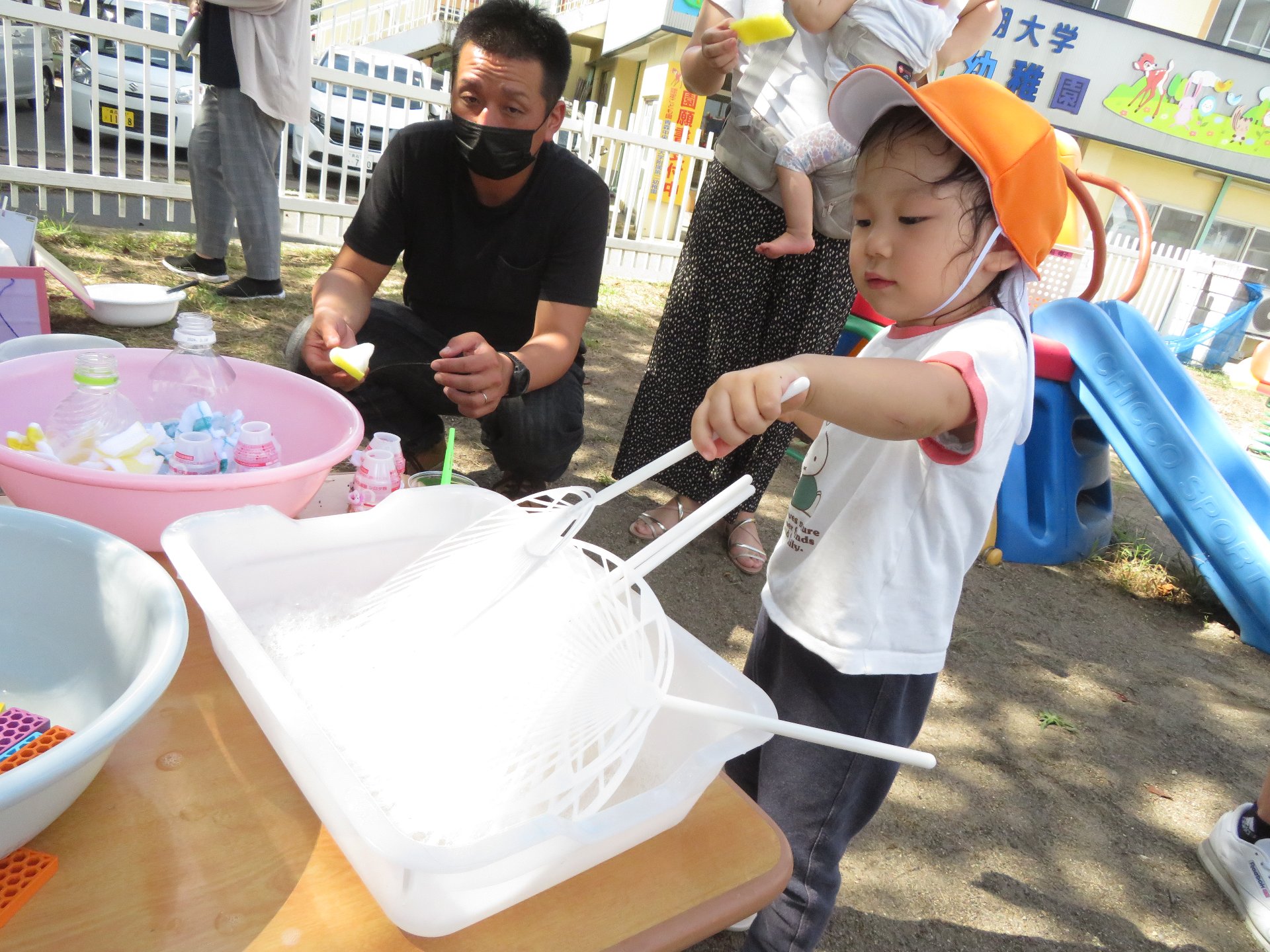 色んな道具を使ってシャボン玉作りに挑戦する園児たち