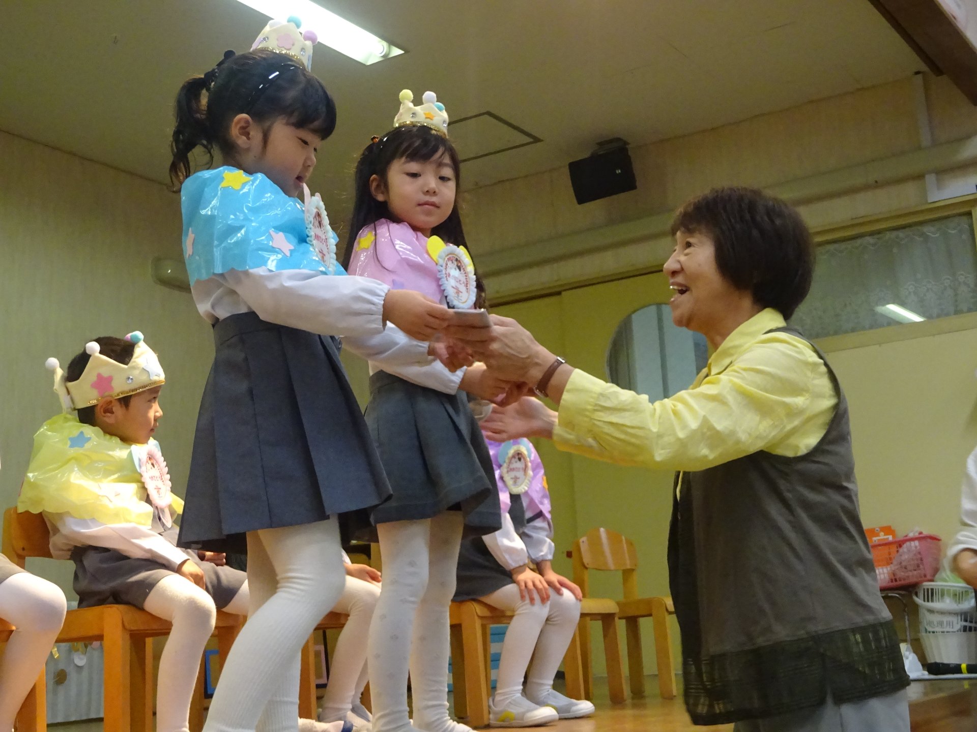 園長先生から誕生カードを受け取る子どもたち