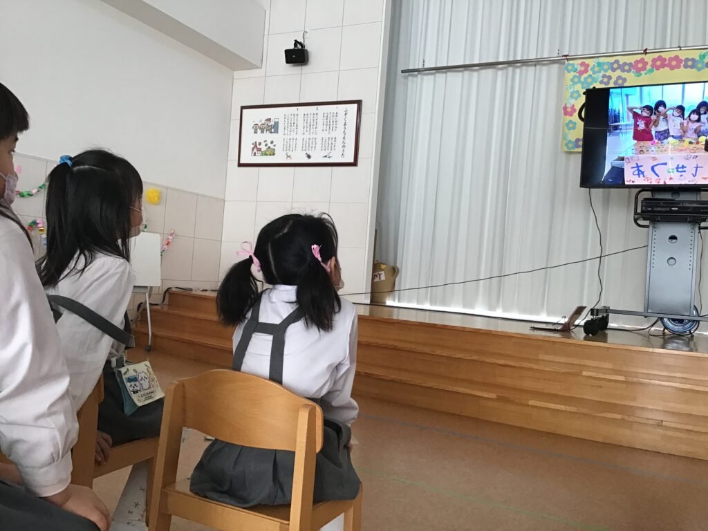 幼稚園の思い出の映像を見る園児たち