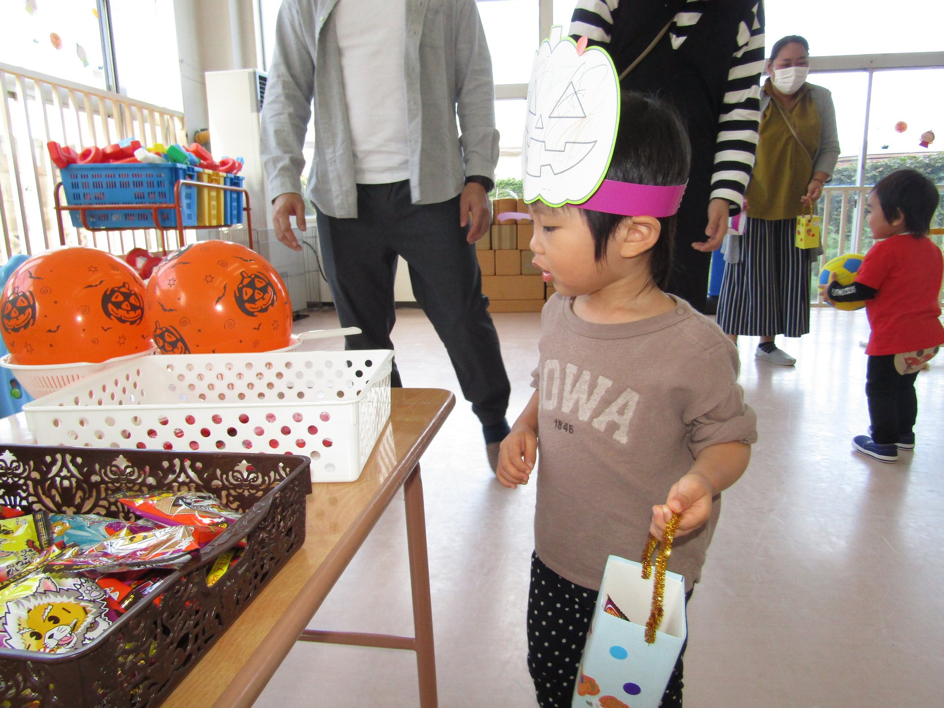 自分で作ったかばんにお菓子を入れる子どもたち