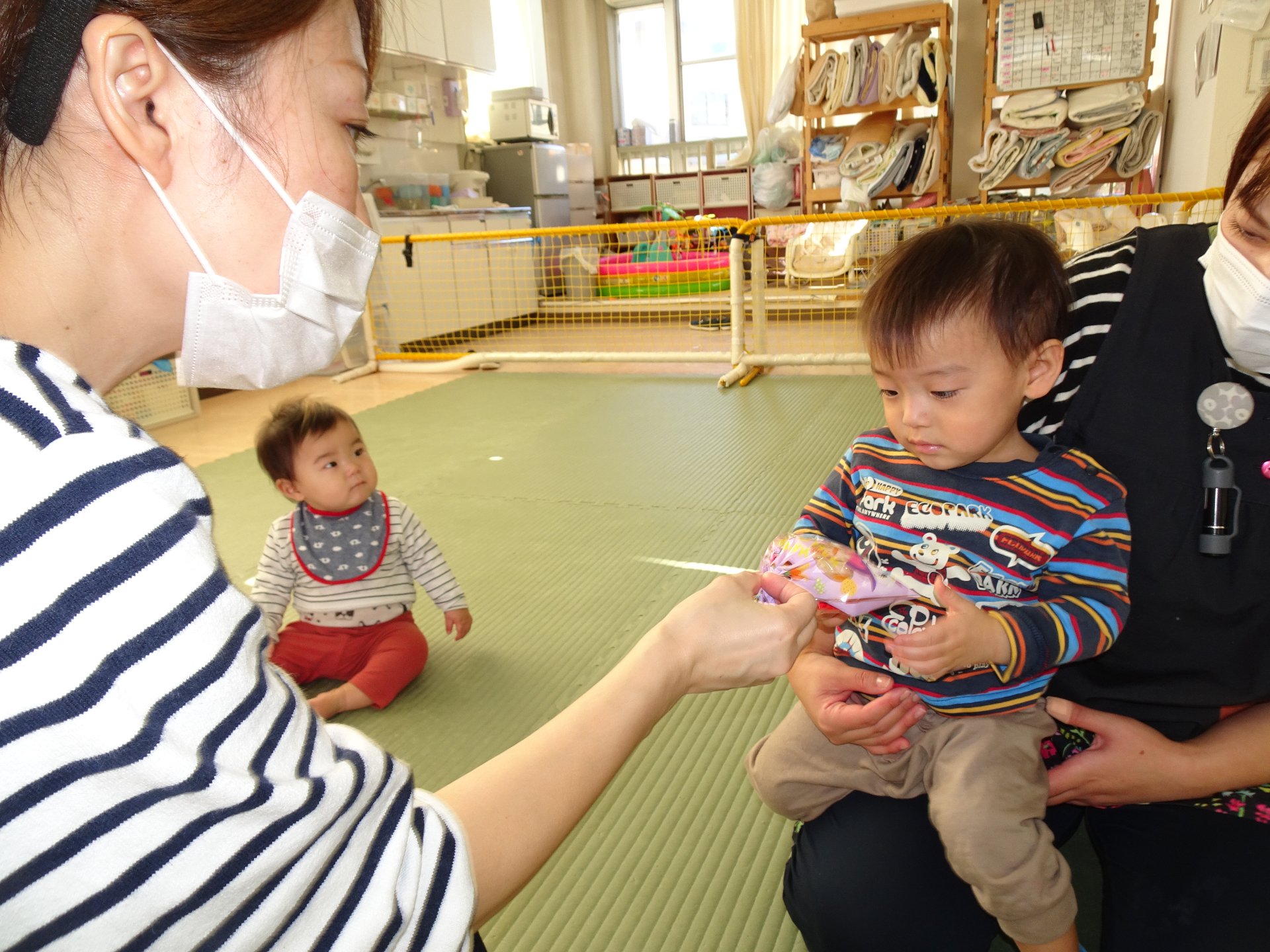 先生からお菓子を受け取る子どもたち