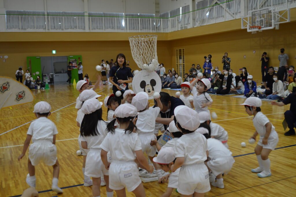 協力して玉入れする園児たち