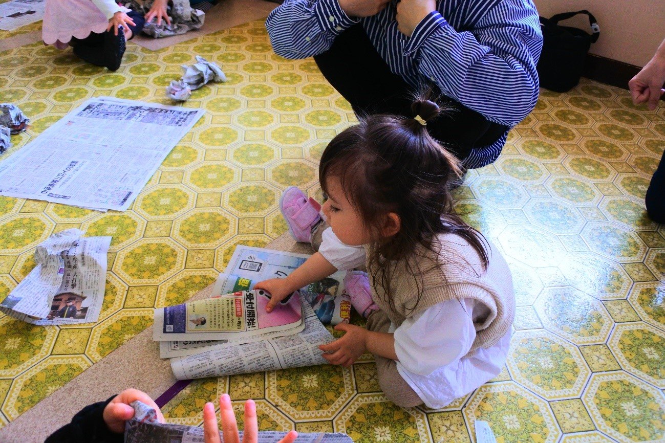 新聞紙・お花紙遊びをする園児たち