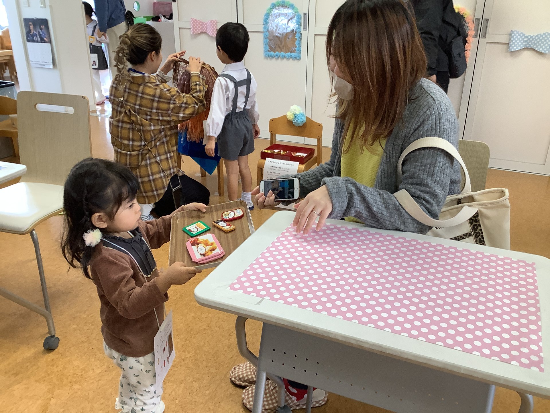 ユニフォームをまとい、店員さん体験をする園児たち