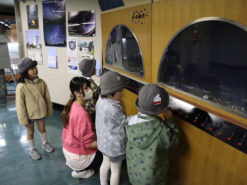 館内の星座に光るボタンを押す園児たち