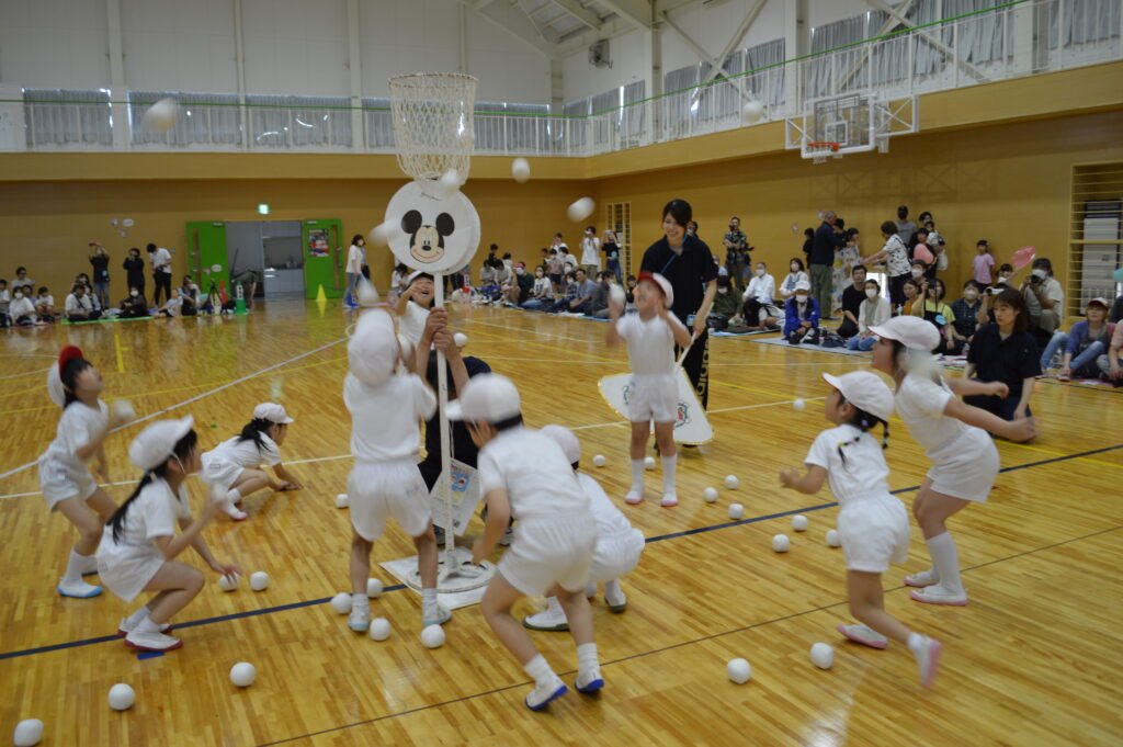 協力して玉入れする園児たち