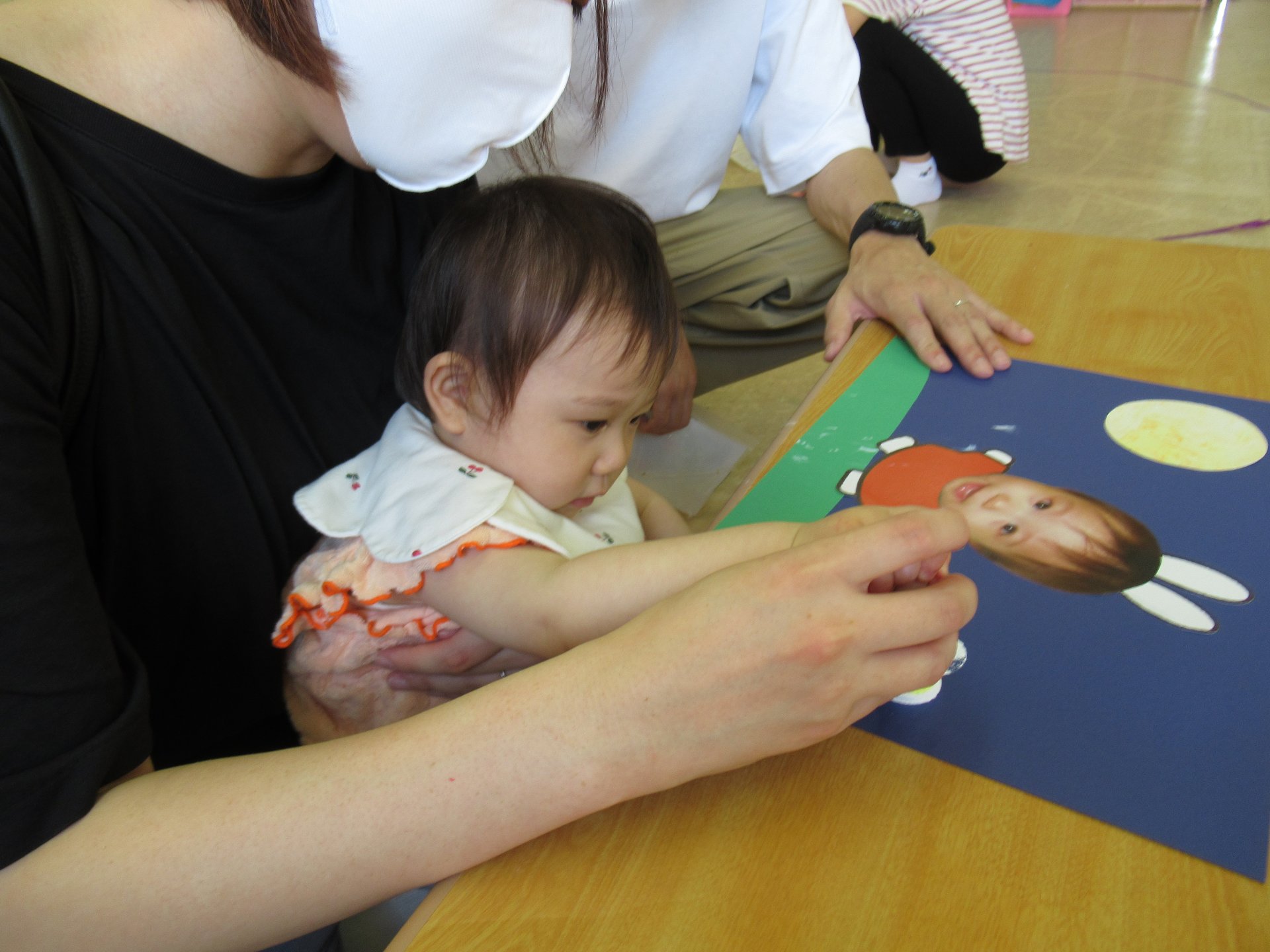 お父さんとお母さんとつづり制作のお団子をスタンプを押す園児