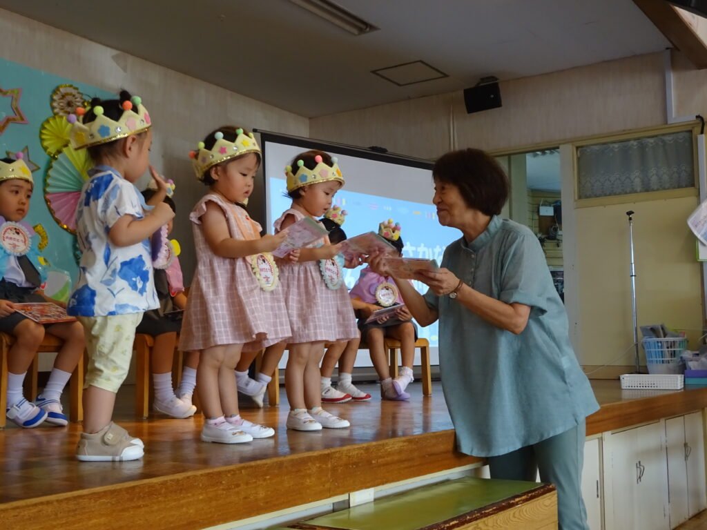 園長先生からお誕生カードを受け取る園児たち