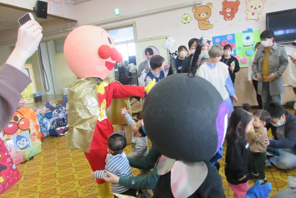 アンパンマン・ばいきんまんとタッチをして喜ぶ子どもたち