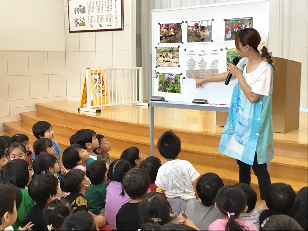 真剣なまなざしでいもほりについて聞く園児たち