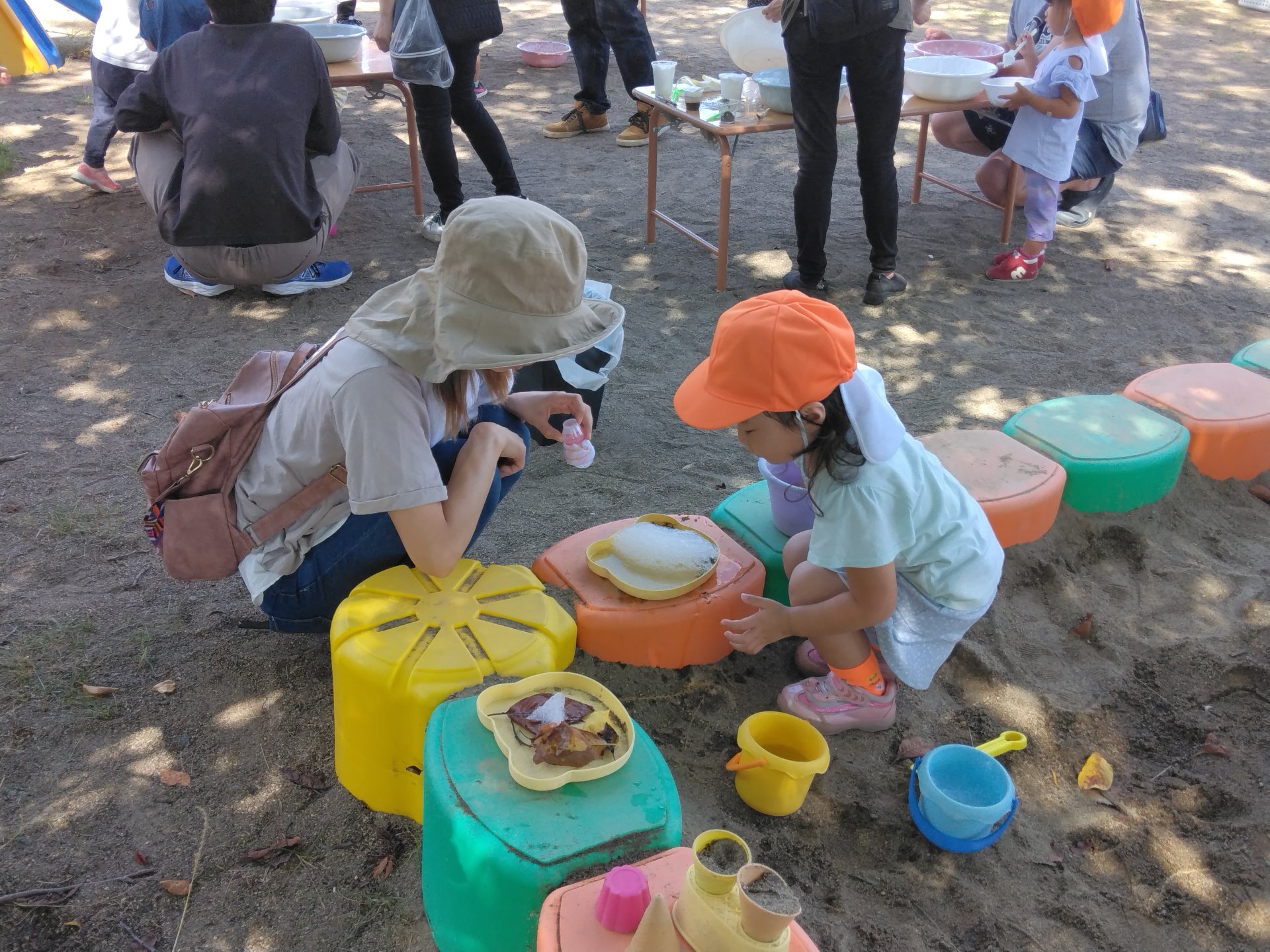 泡を砂の上に賭けて実験する園児たち
